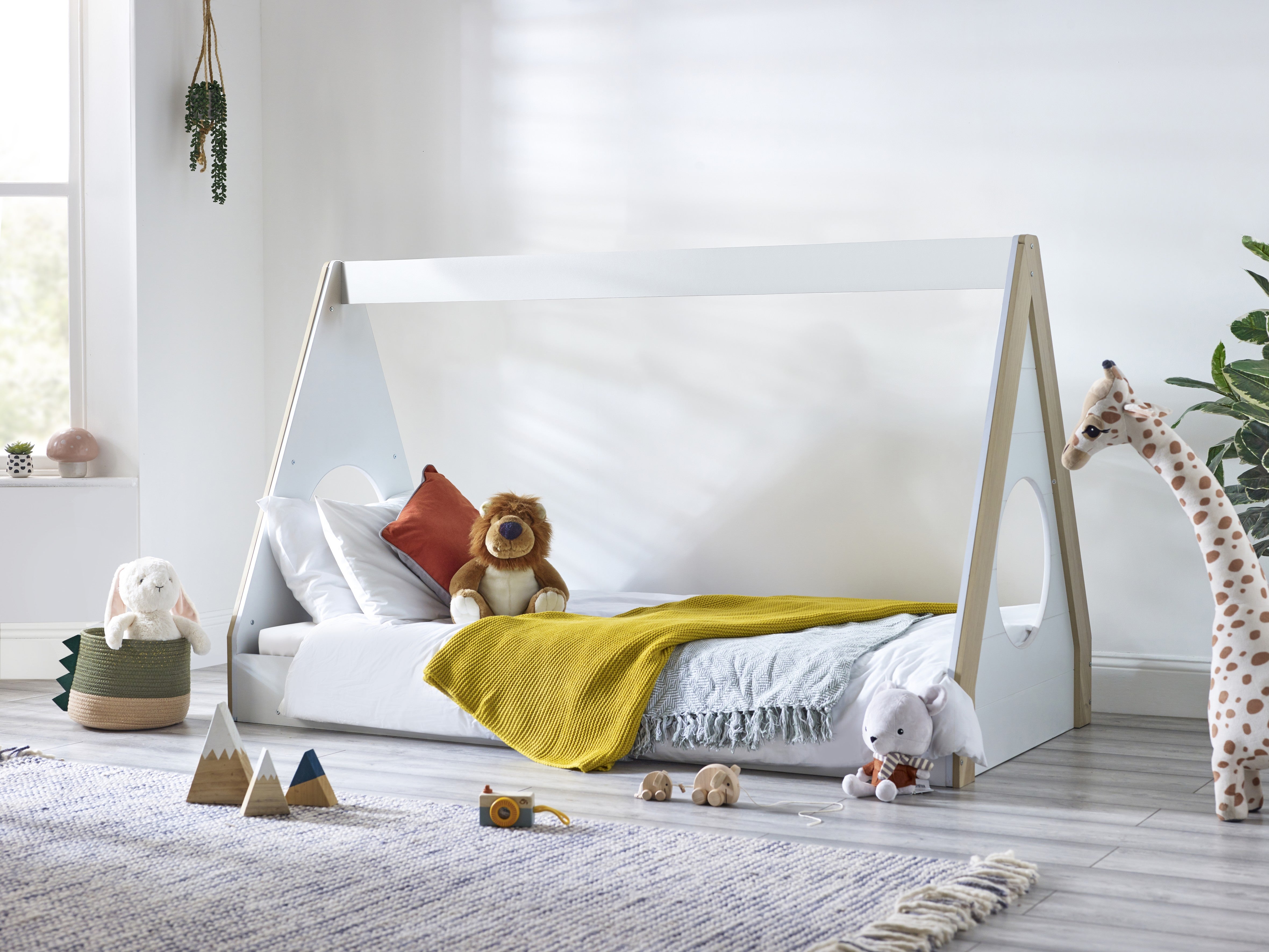 Children's room with a white bed shaped like a tent, toys, and decorative elements.
