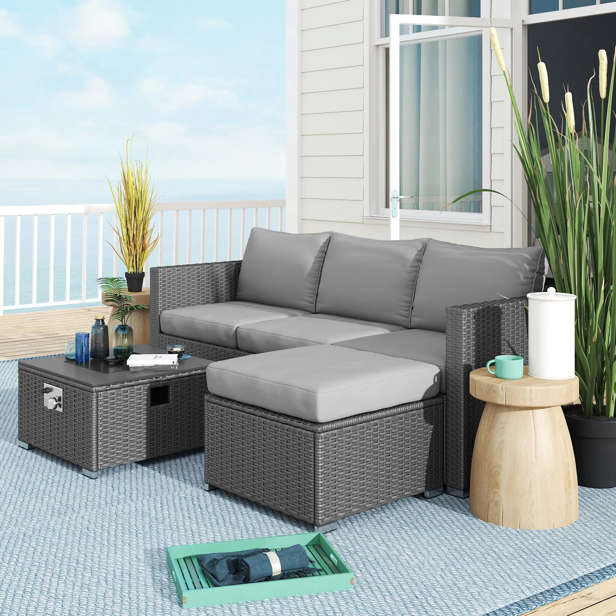 Outdoor patio furniture set with gray sectional sofa, coffee table, and side table on a deck.