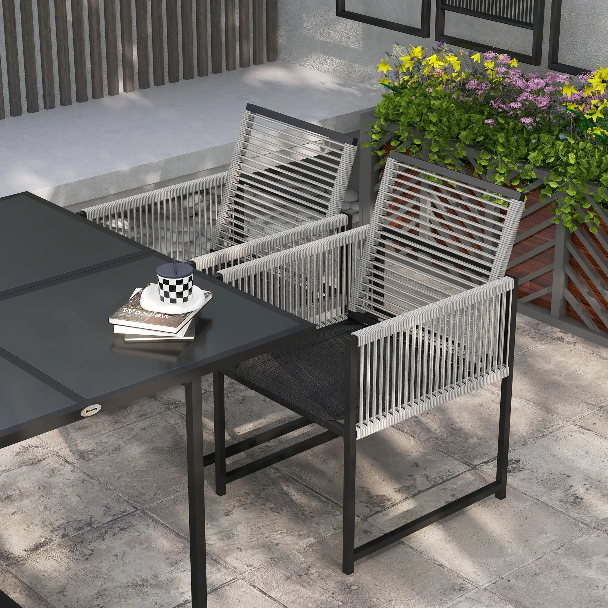 Outdoor dining set with a table and chairs on a stone patio.