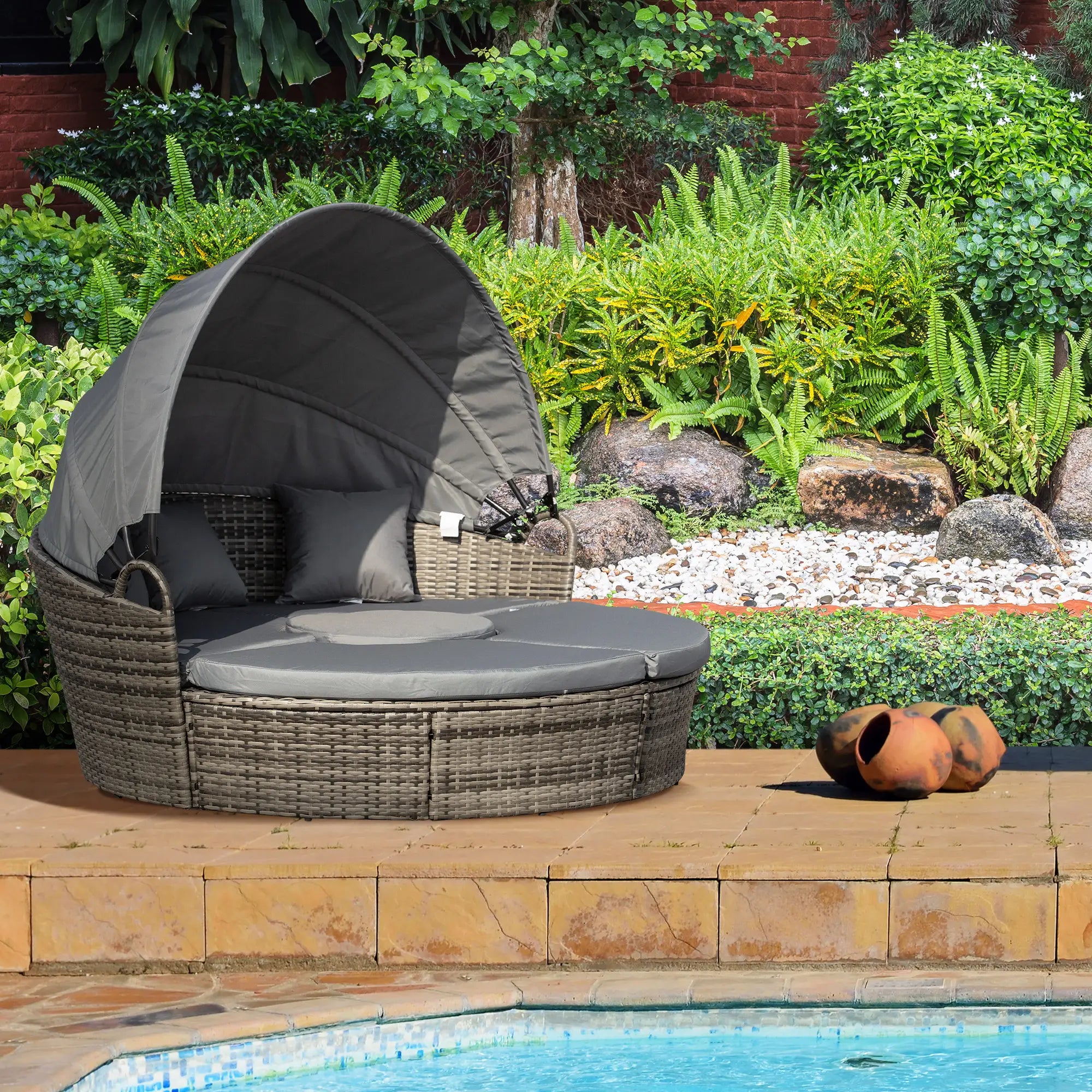 Outdoor wicker daybed with canopy by a poolside garden
