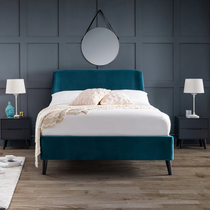 Teal bed frame with white bedding in a bedroom setting.