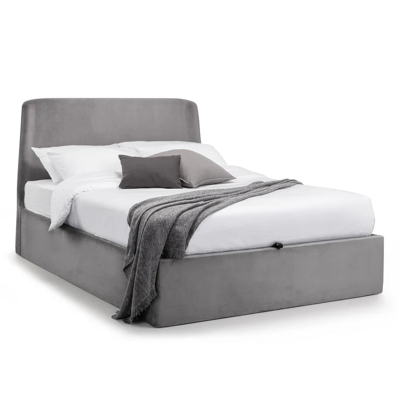 Gray upholstered bed with white bedding and gray blanket on a white background