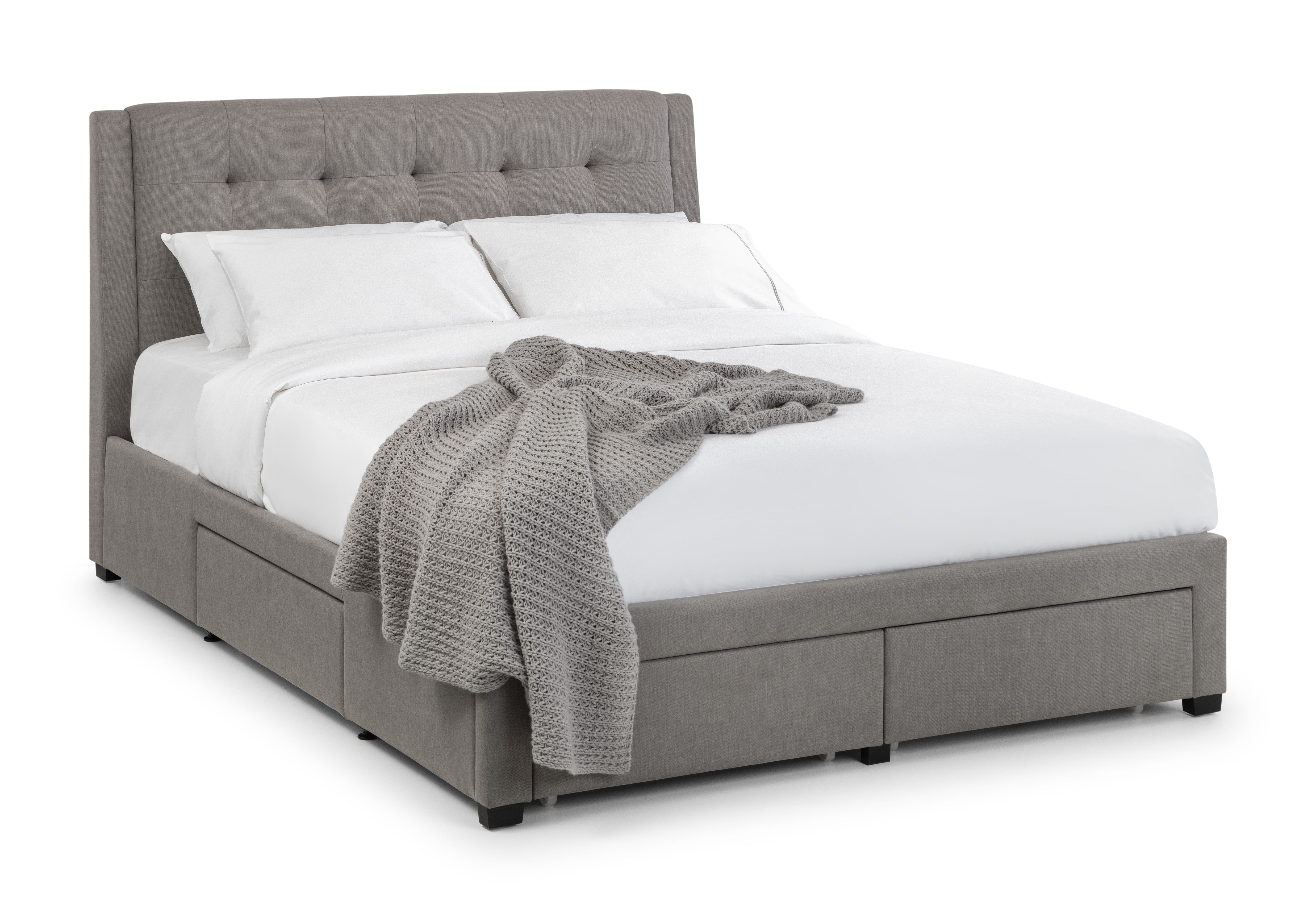 Gray upholstered bed with white bedding and a gray blanket on a white background