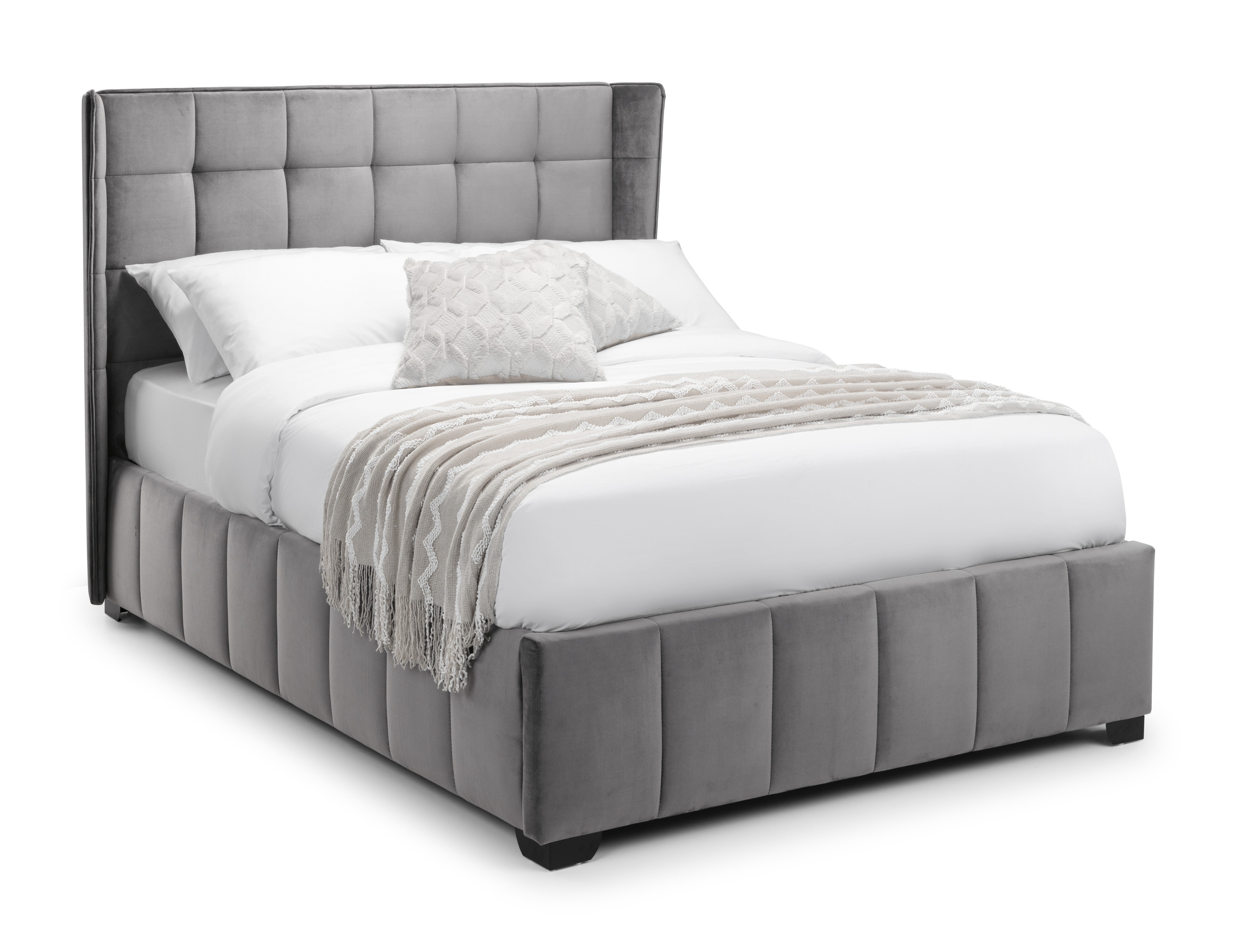 Gray upholstered bed with white bedding on a white background