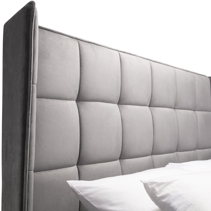 Gray upholstered headboard with tufted design on a white background