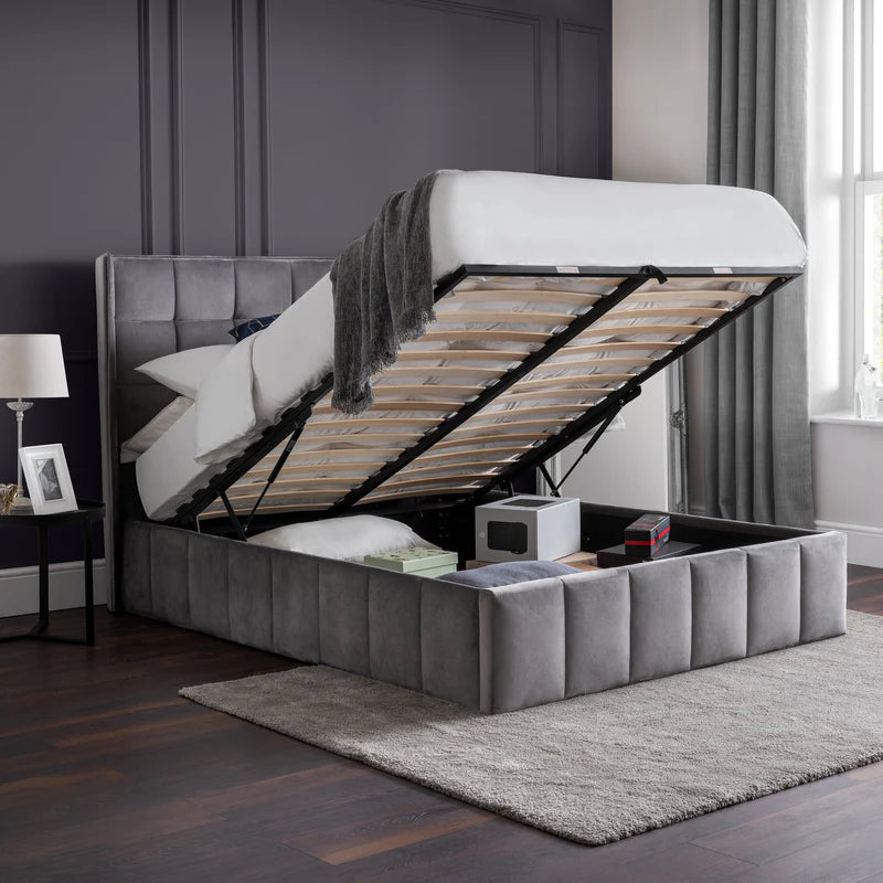 Gray upholstered bed with open storage compartment in a bedroom setting.
