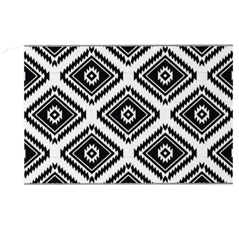 Black and white geometric patterned rug on a white background
