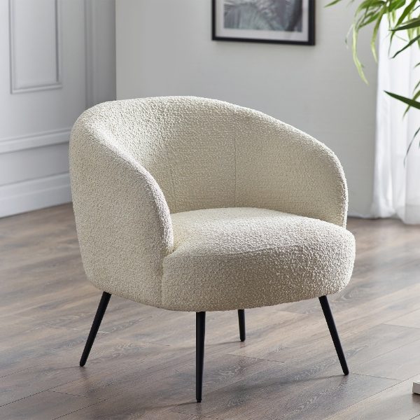 Cream-colored textured armchair on a wooden floor with a neutral background