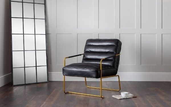 Black leather chair with gold frame in a room with a large window.