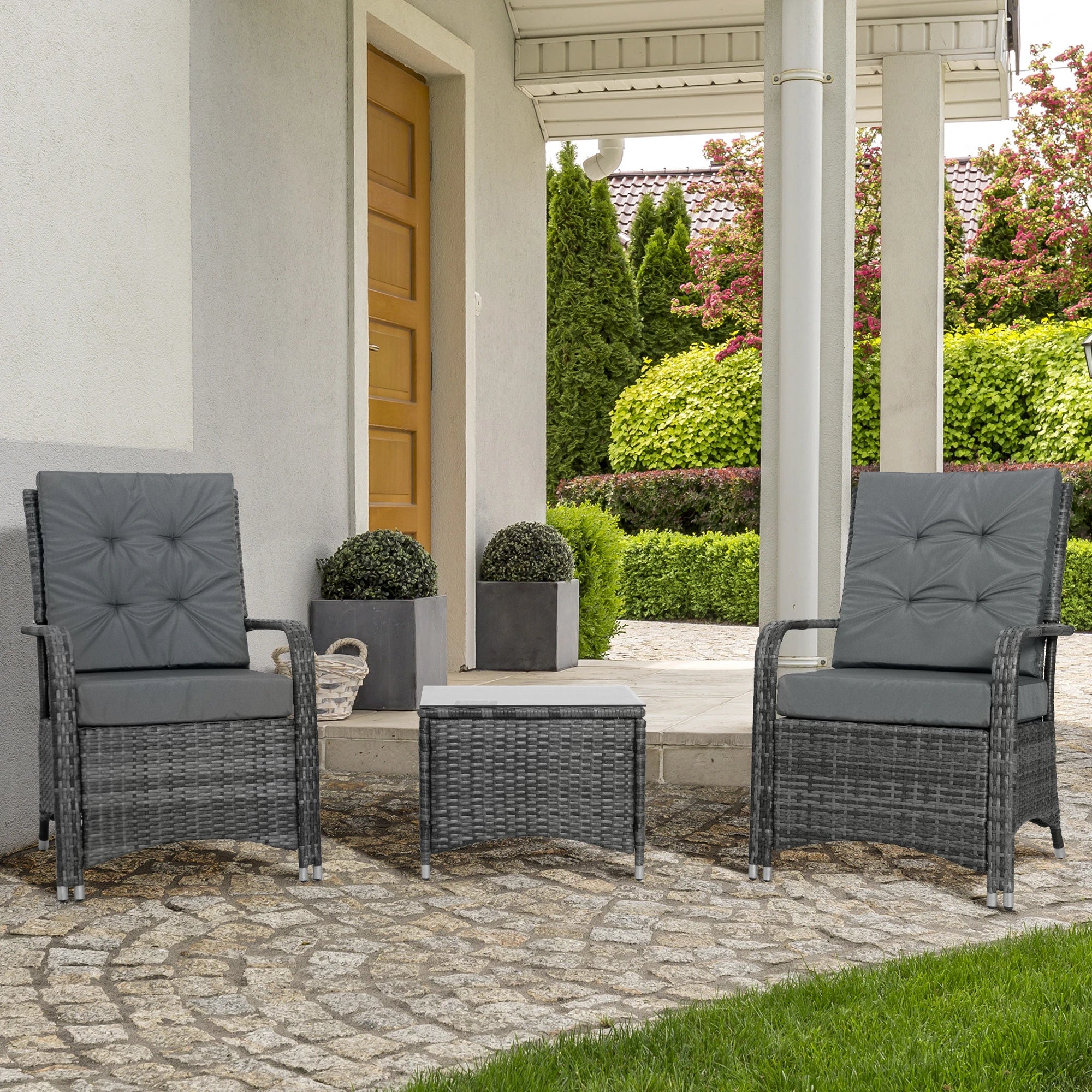 Outdoor patio set with two chairs and a table on a stone patio.