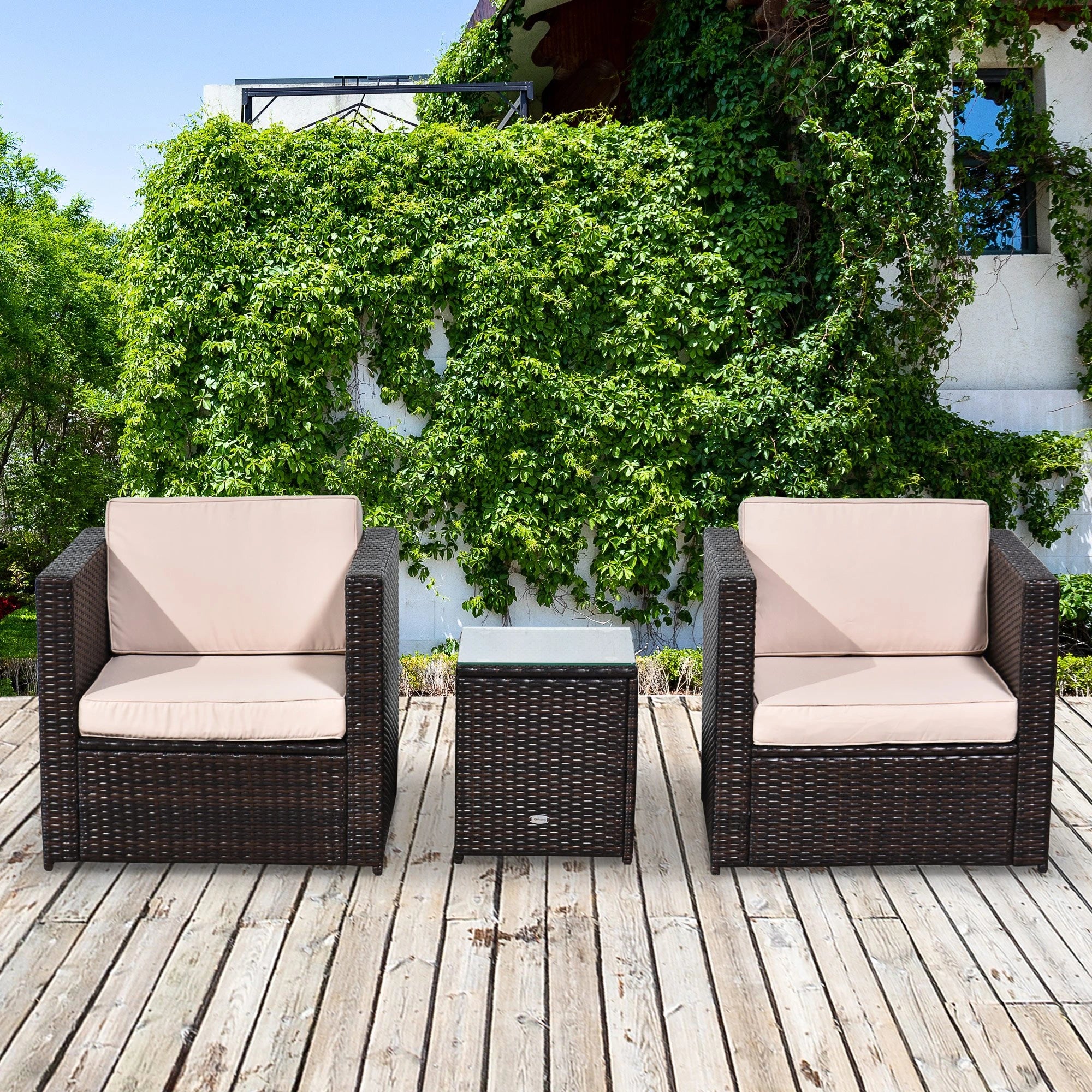 Outdoor patio set with two chairs and a table on a wooden deck, surrounded by greenery.