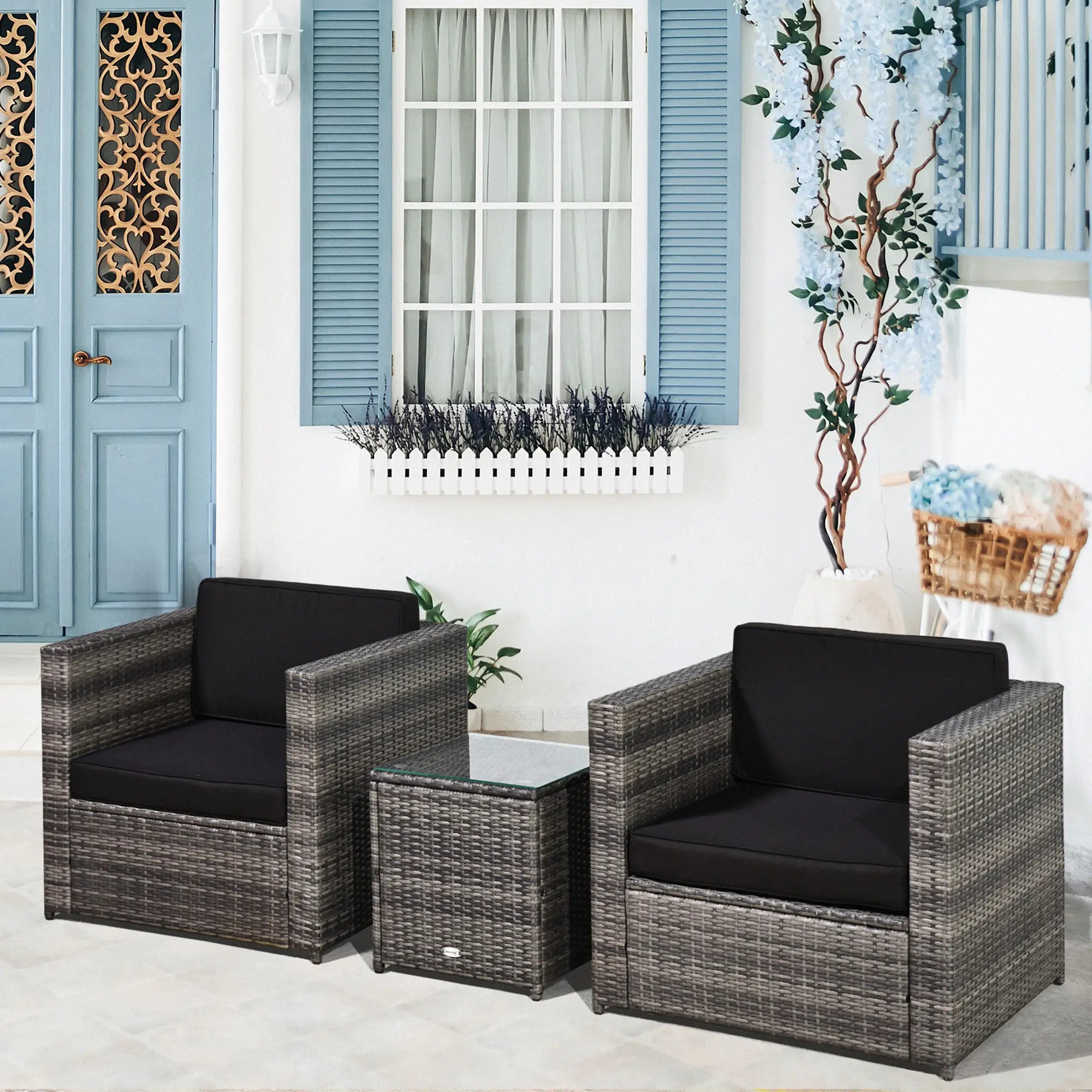 Outdoor patio set with two chairs and a table in front of a blue door and window.