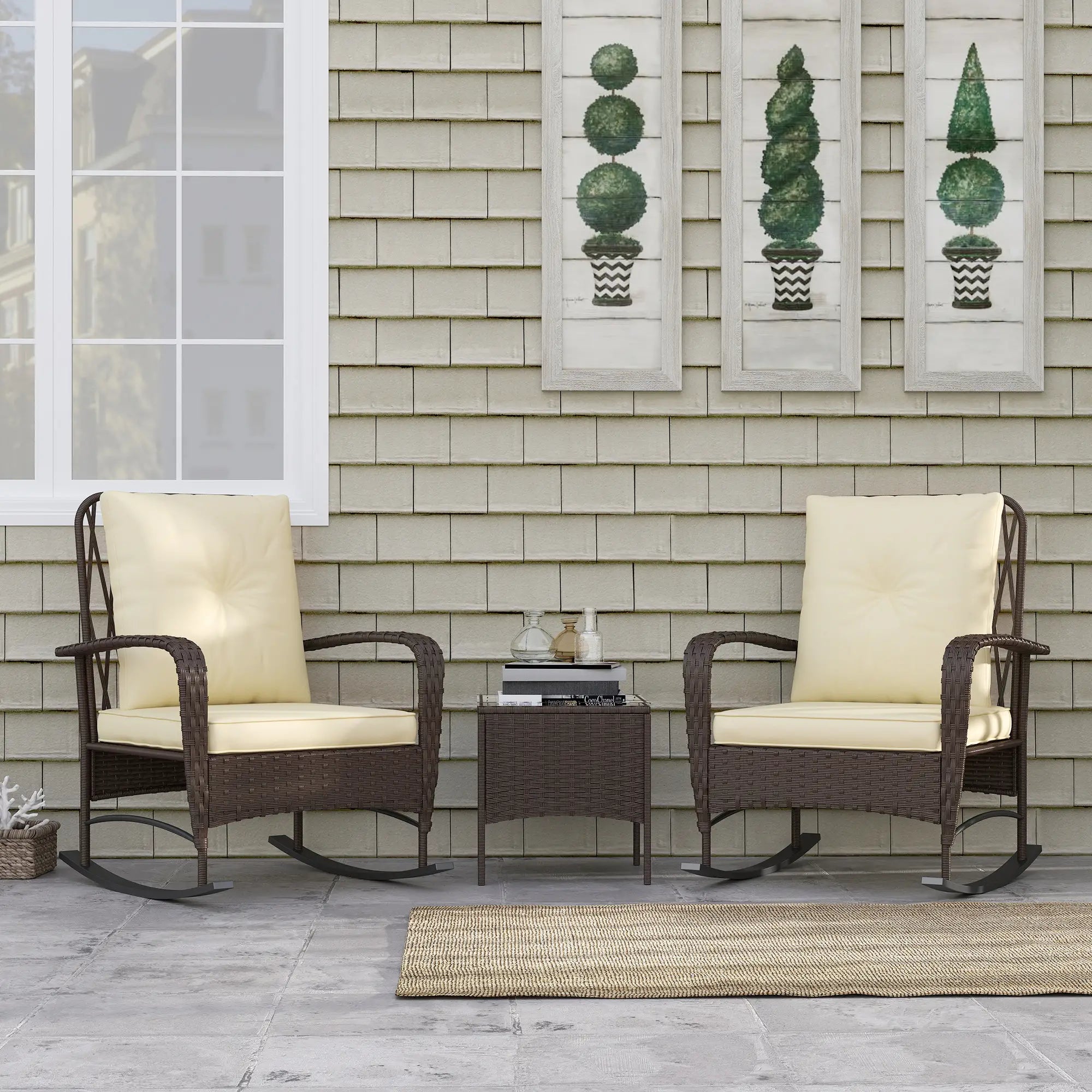 Outdoor patio set with two rocking chairs and a small table against a shingled wall.