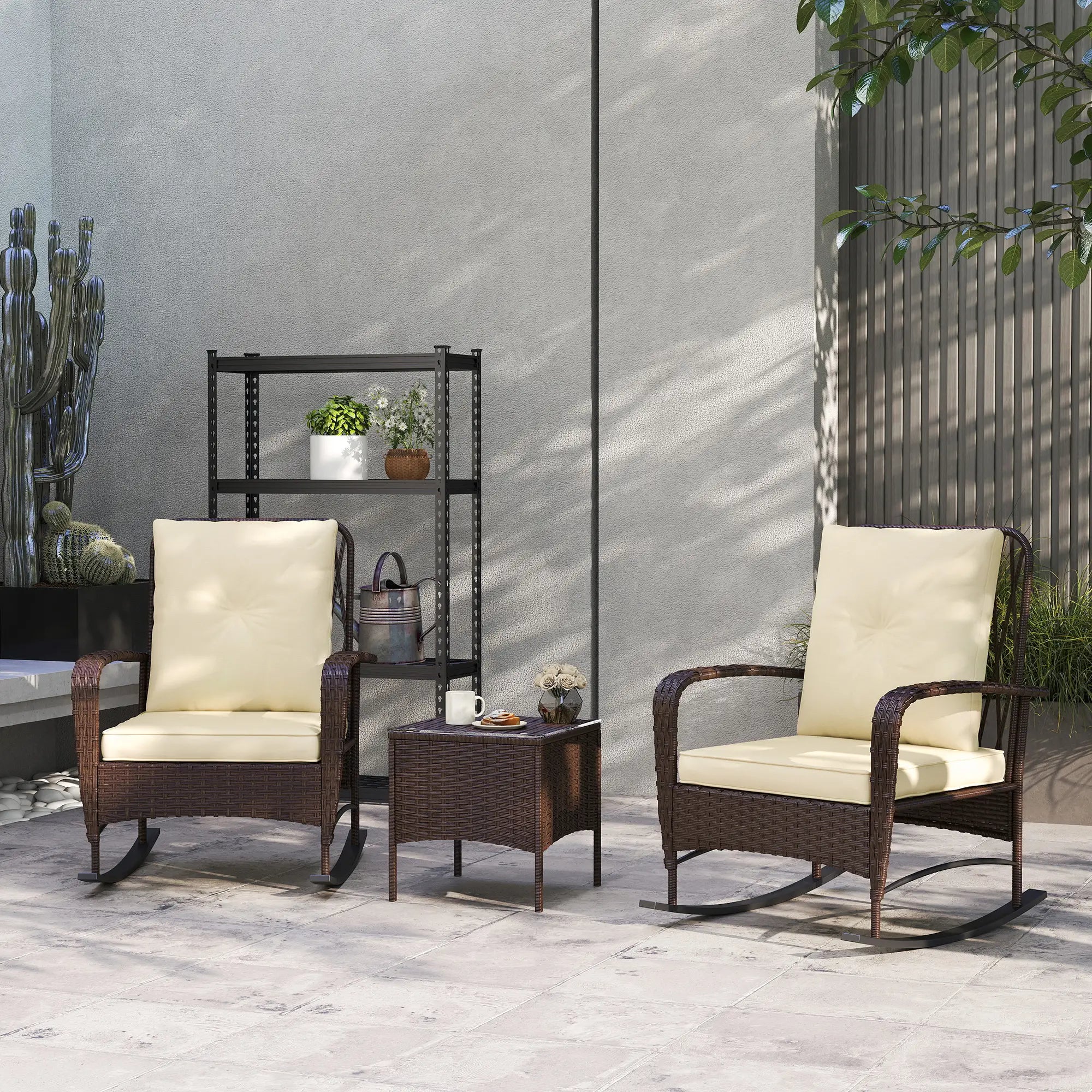 Two wicker rocking chairs with beige cushions on a patio, accompanied by a small table and decorative items.