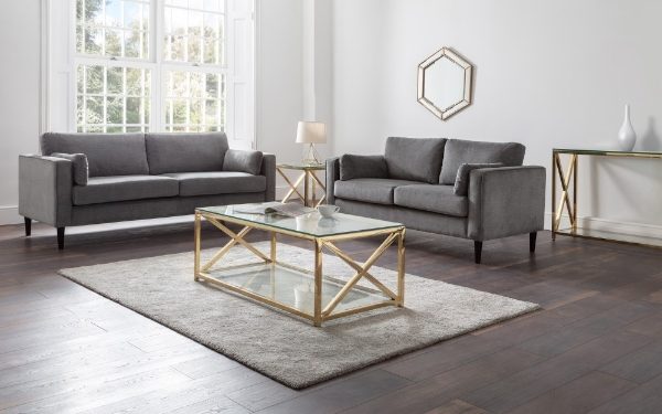Modern living room with gray sofas, a glass coffee table, and decorative elements.