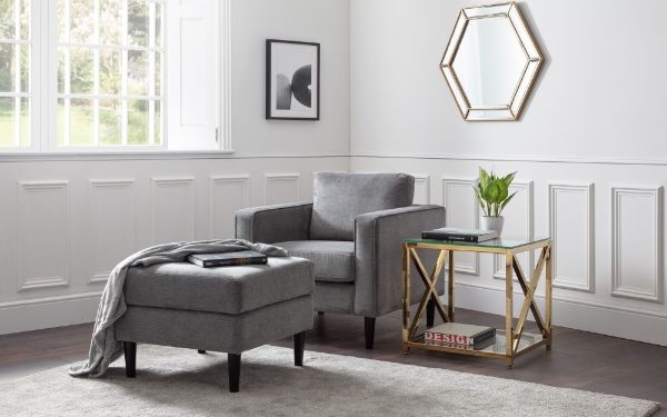 Gray armchair and ottoman with a side table in a living room setting.