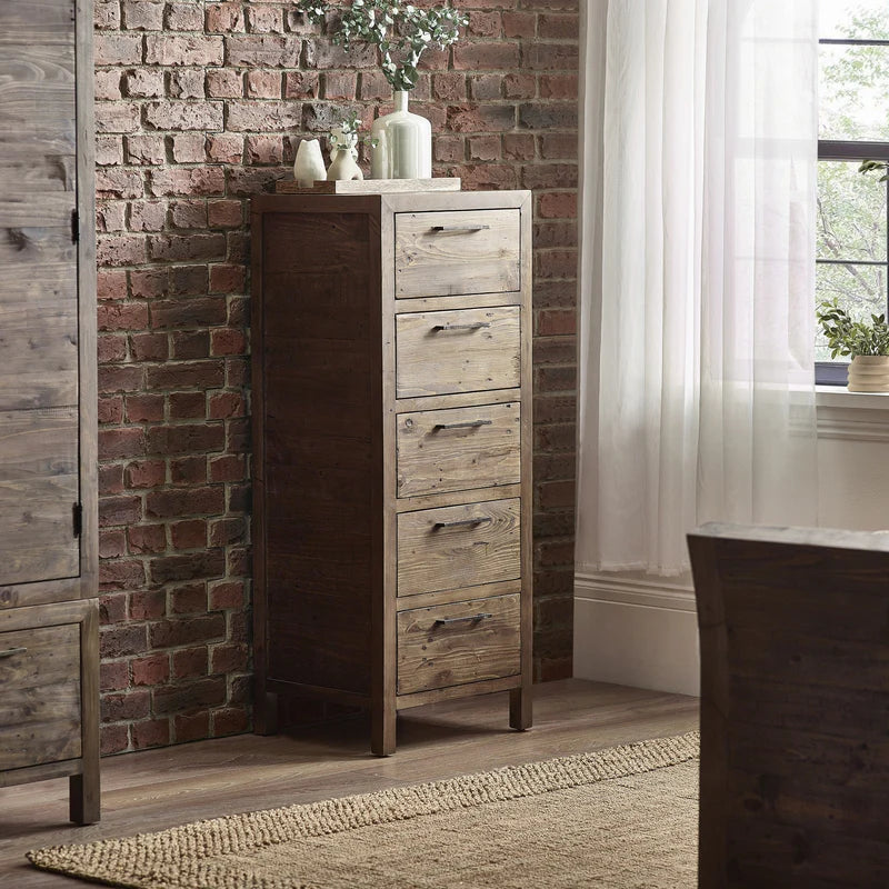 Wooden dresser against a brick wall with decorative items on top