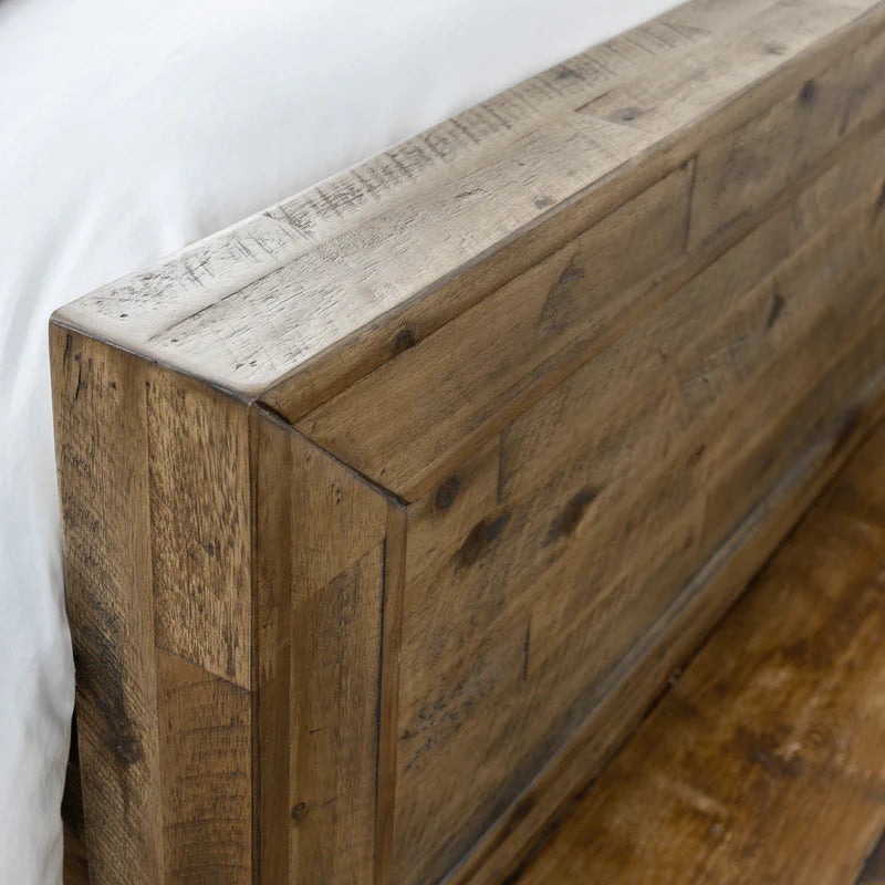 Close-up of a wooden headboard with a rustic finish.