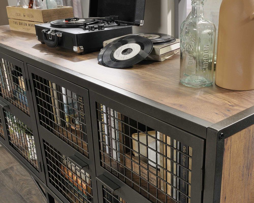 Record player on a wooden surface with a grid-patterned cabinet in the foreground