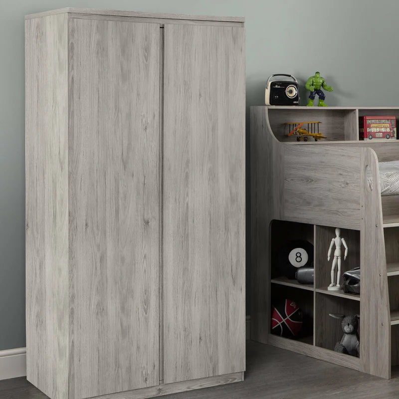 Wooden wardrobe and children's bed with toys in a room.
