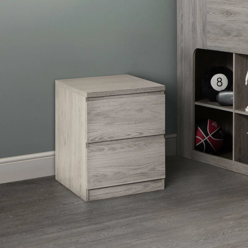 Wooden nightstand with two drawers against a gray wall.
