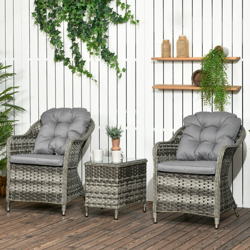 Outdoor furniture set with two chairs and a table on a wooden deck, against a white paneled wall with plants.