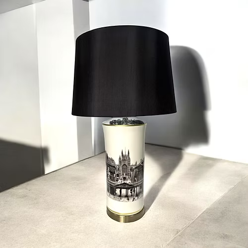 Lamp with black shade and decorative base on a light surface