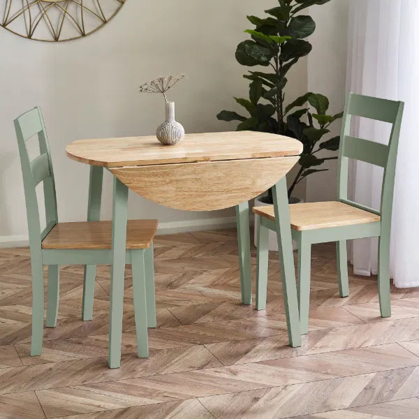 Dining set with wooden table and green chairs on a herringbone floor.