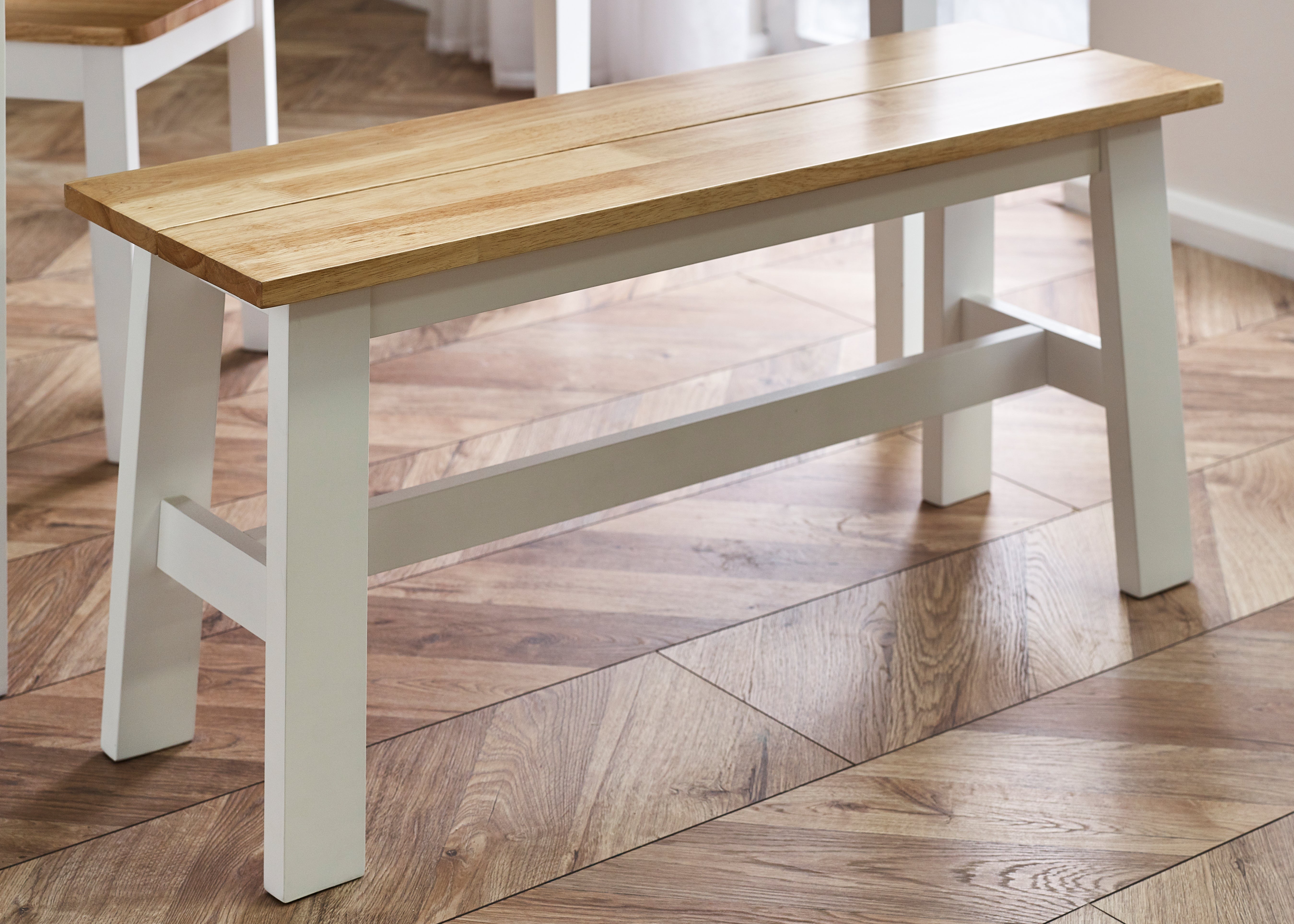 Wooden bench with white legs on a wooden floor