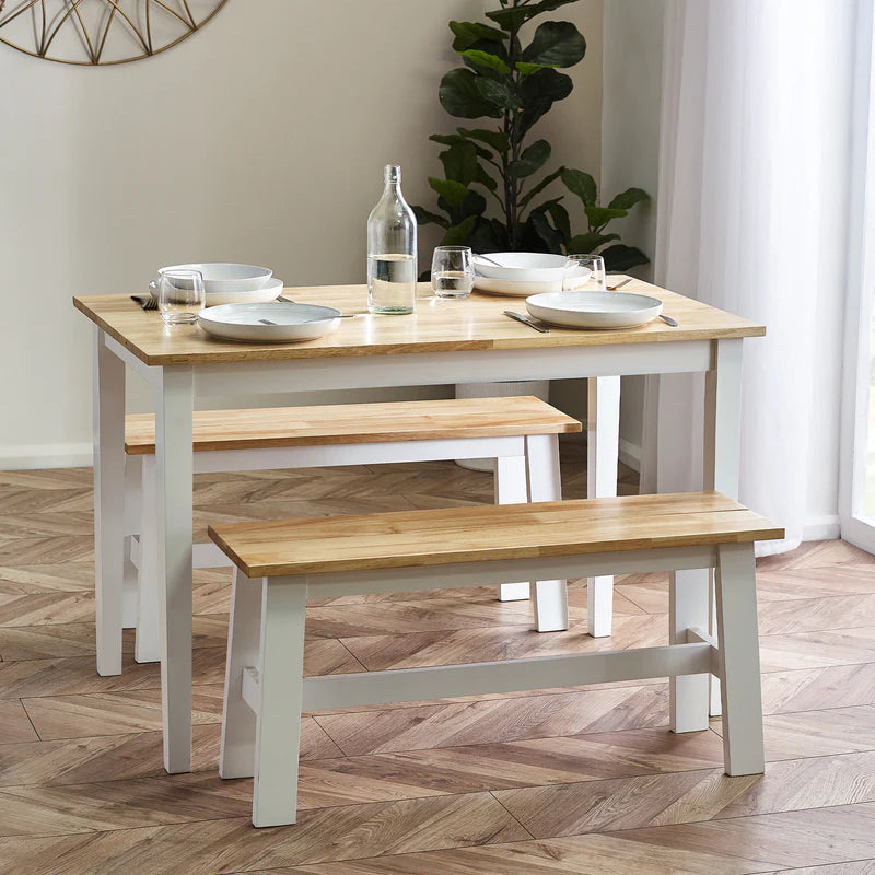 Dining table set with chairs and a bench on a wooden floor.