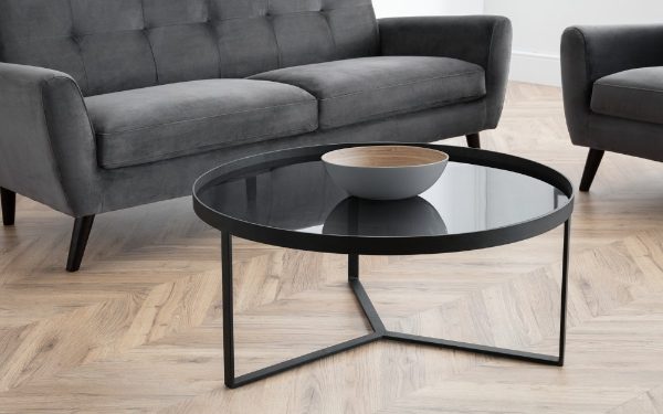 Modern living room with a gray sofa and glass coffee table.