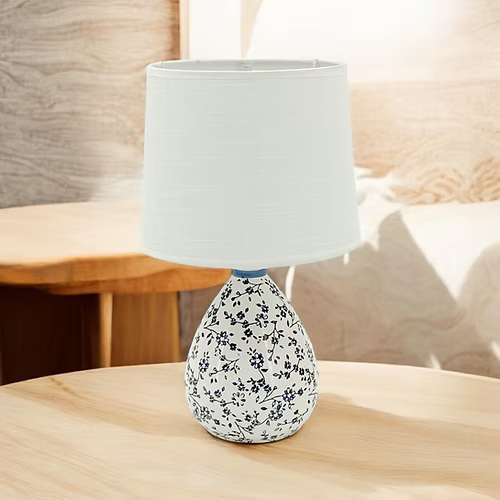 Decorative table lamp with floral pattern on a wooden surface