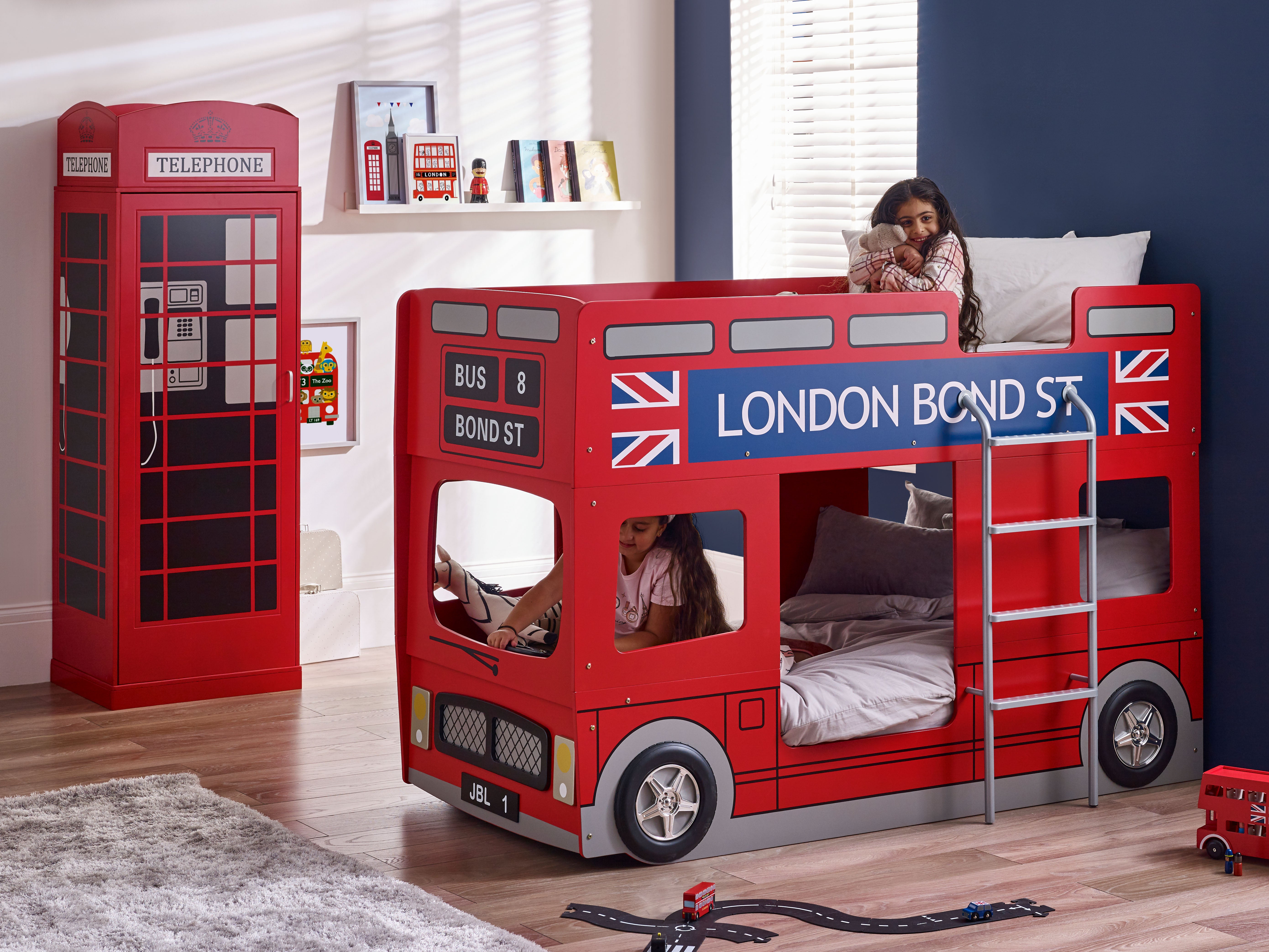 Children's room with a red double-decker bus bed and British telephone box.
