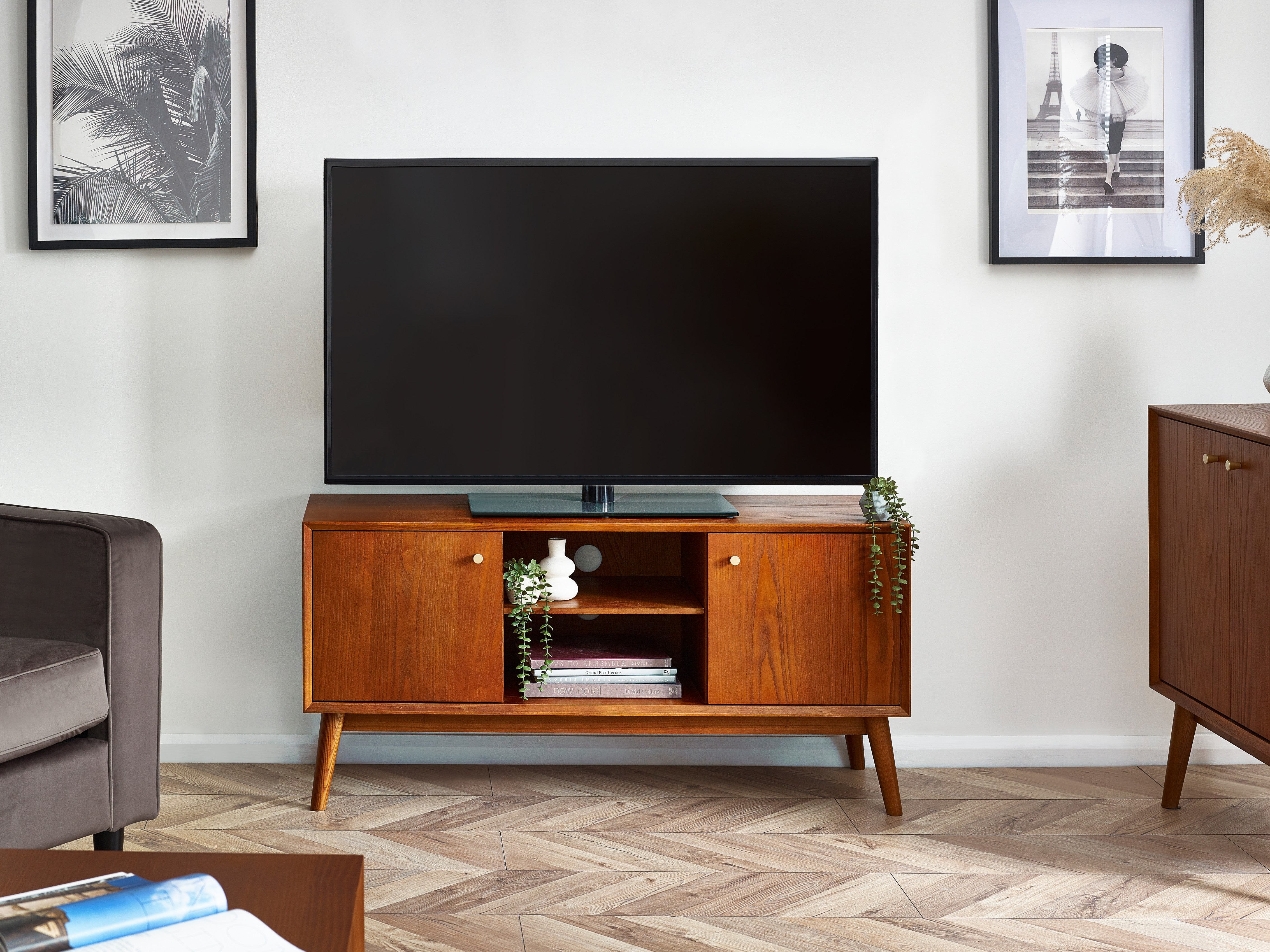Wooden TV stand with a television in a living room setting.