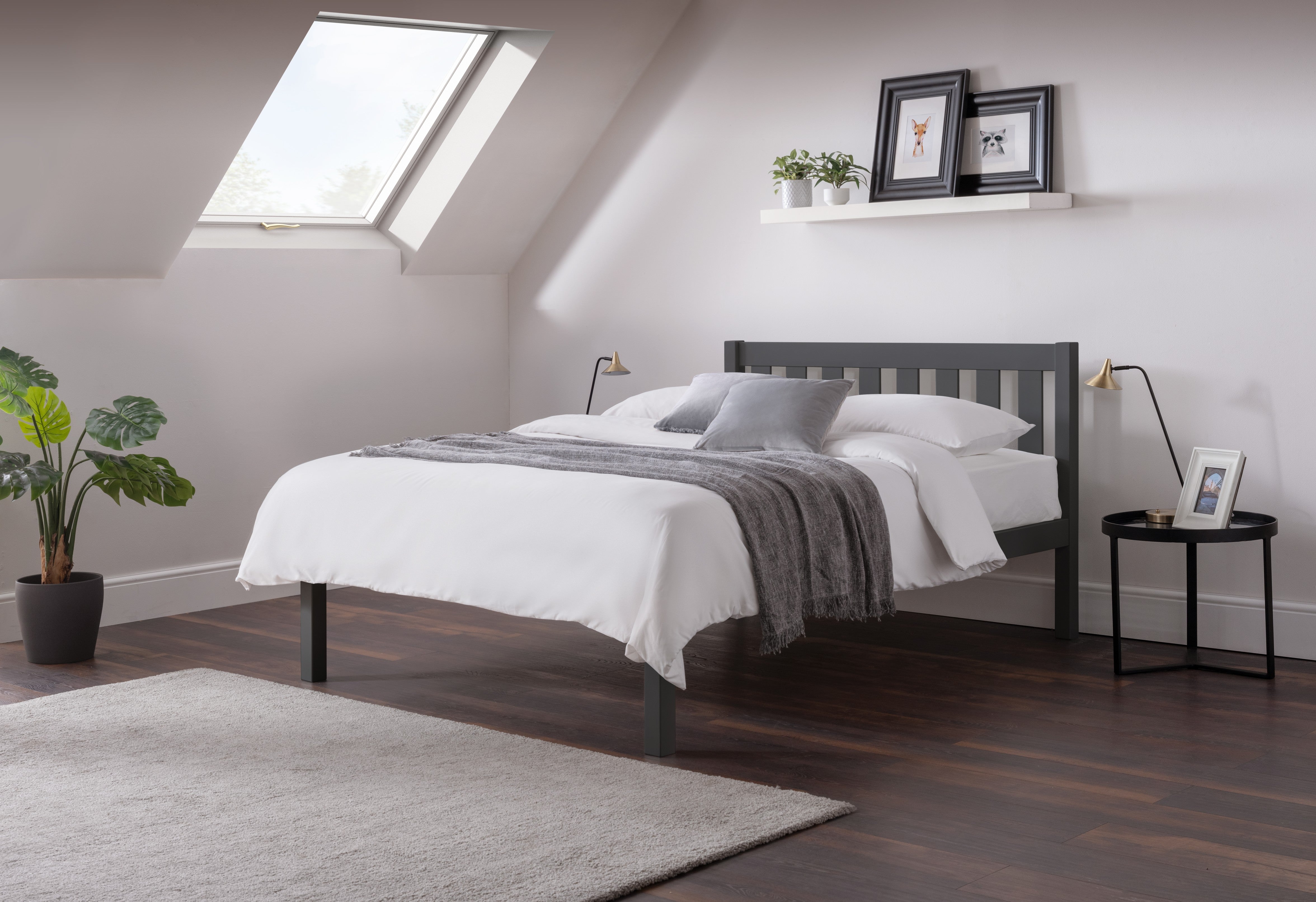 Grey bed frame with white duvet in a bedroom setting. 