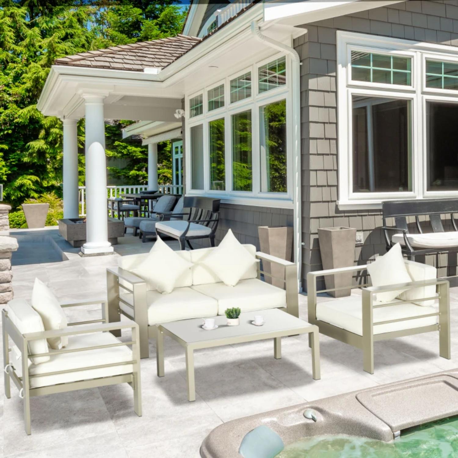 Outdoor patio furniture set with cushions in front of a house.