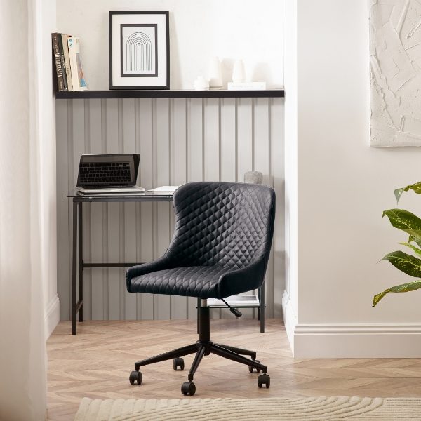 Black office chair in a home office setting with a desk and decor.