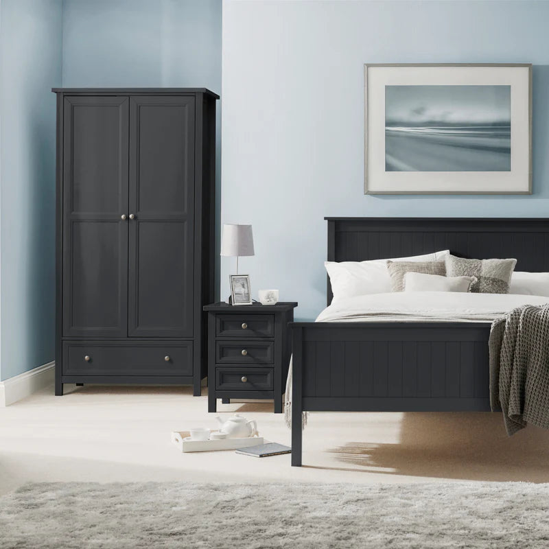 Black bedroom furniture set with a bed and wardrobe against a light blue wall.