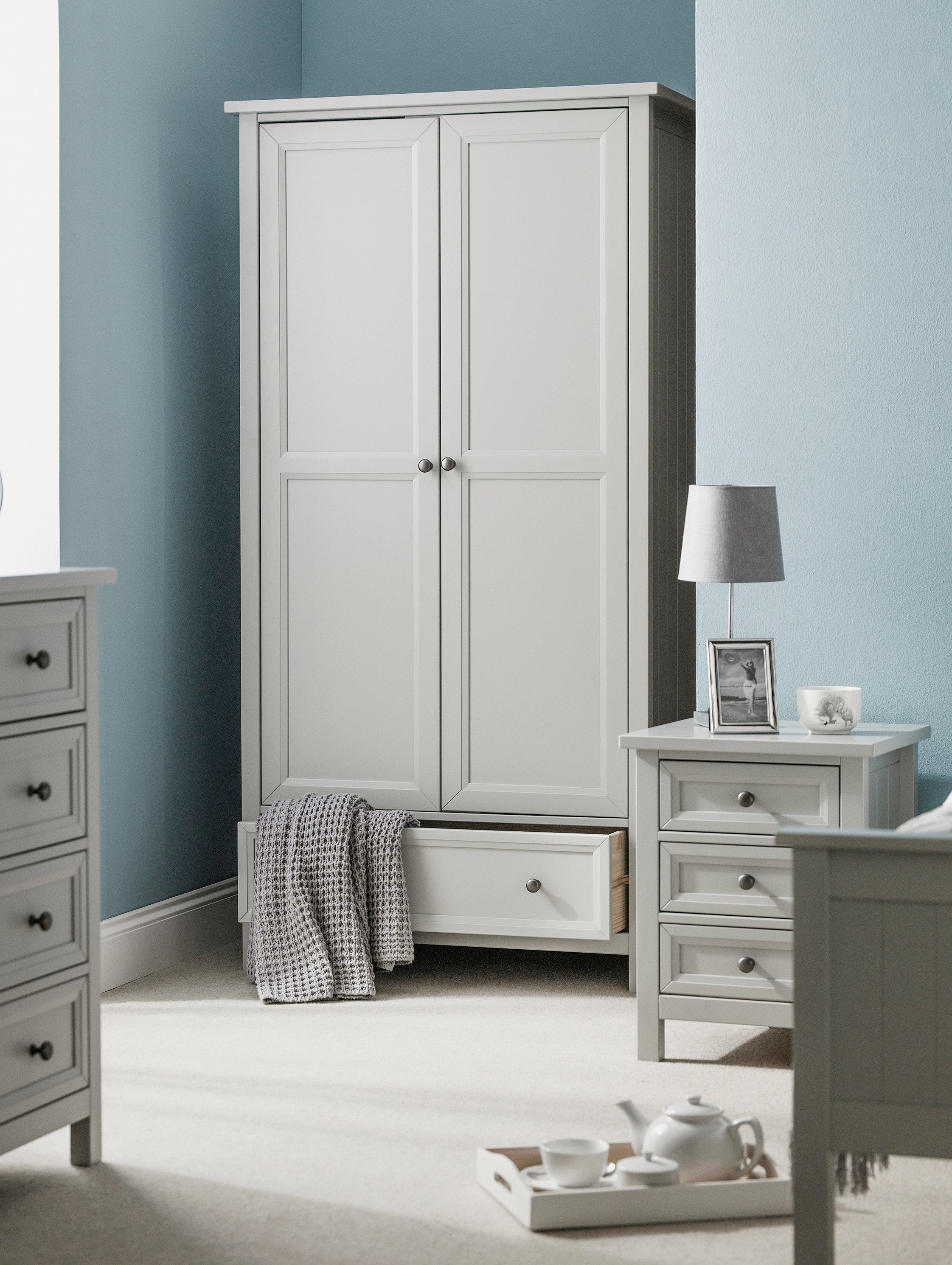 Gray wardrobe in a bedroom with matching furniture and decor.