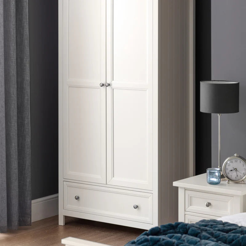 White wardrobe with a nightstand and lamp in a bedroom setting