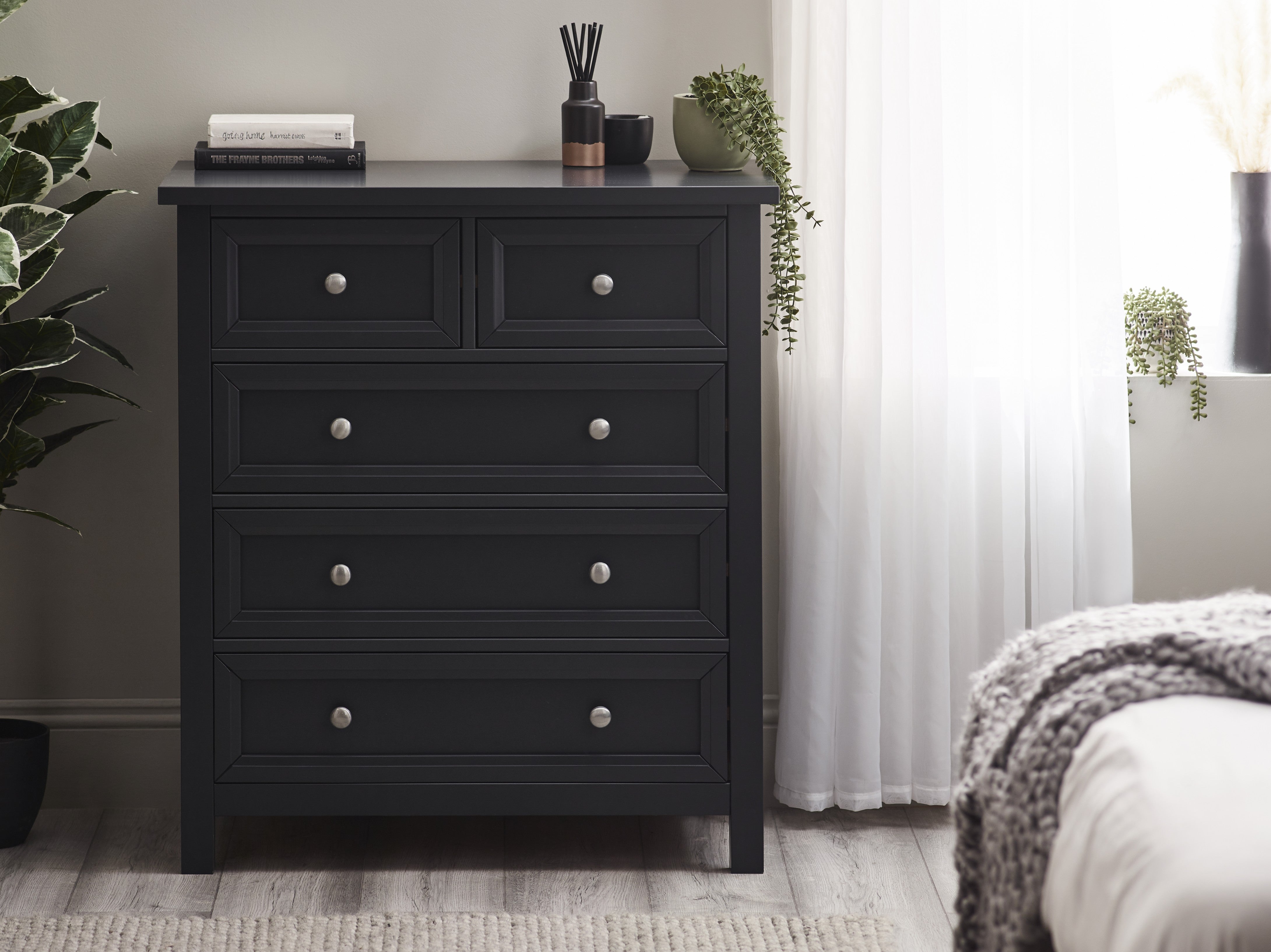 Grey dresser with multiple drawers in a bedroom setting