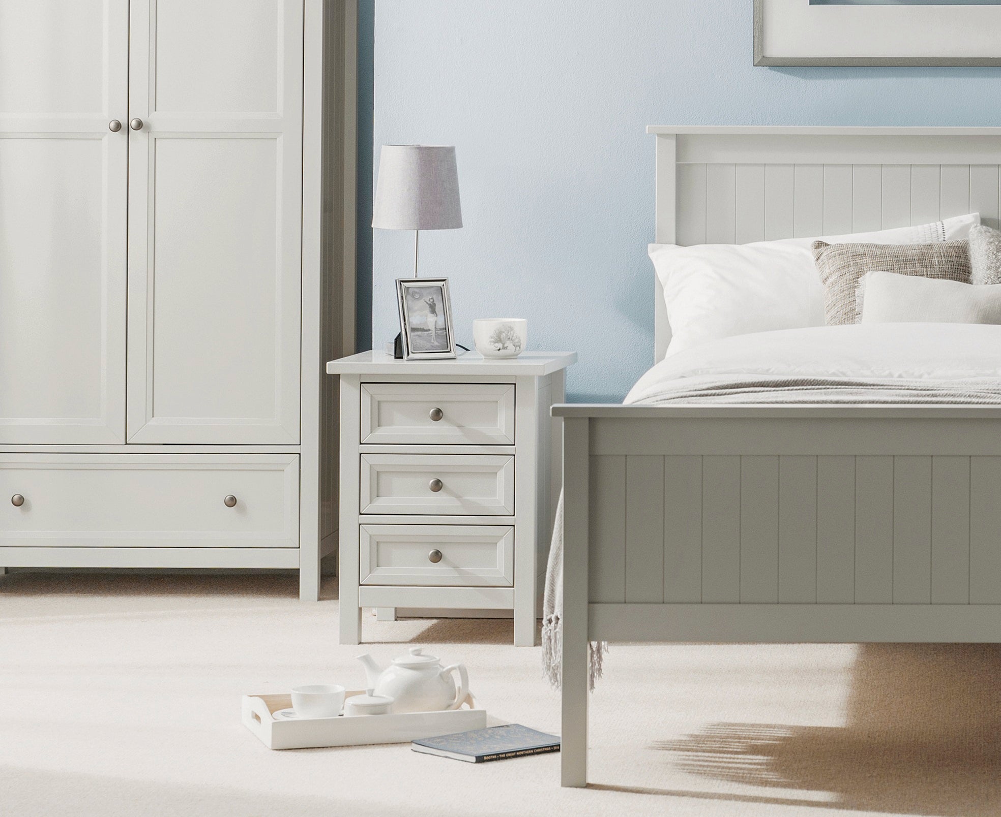Neatly arranged bedroom with a bed, nightstand, and wardrobe.