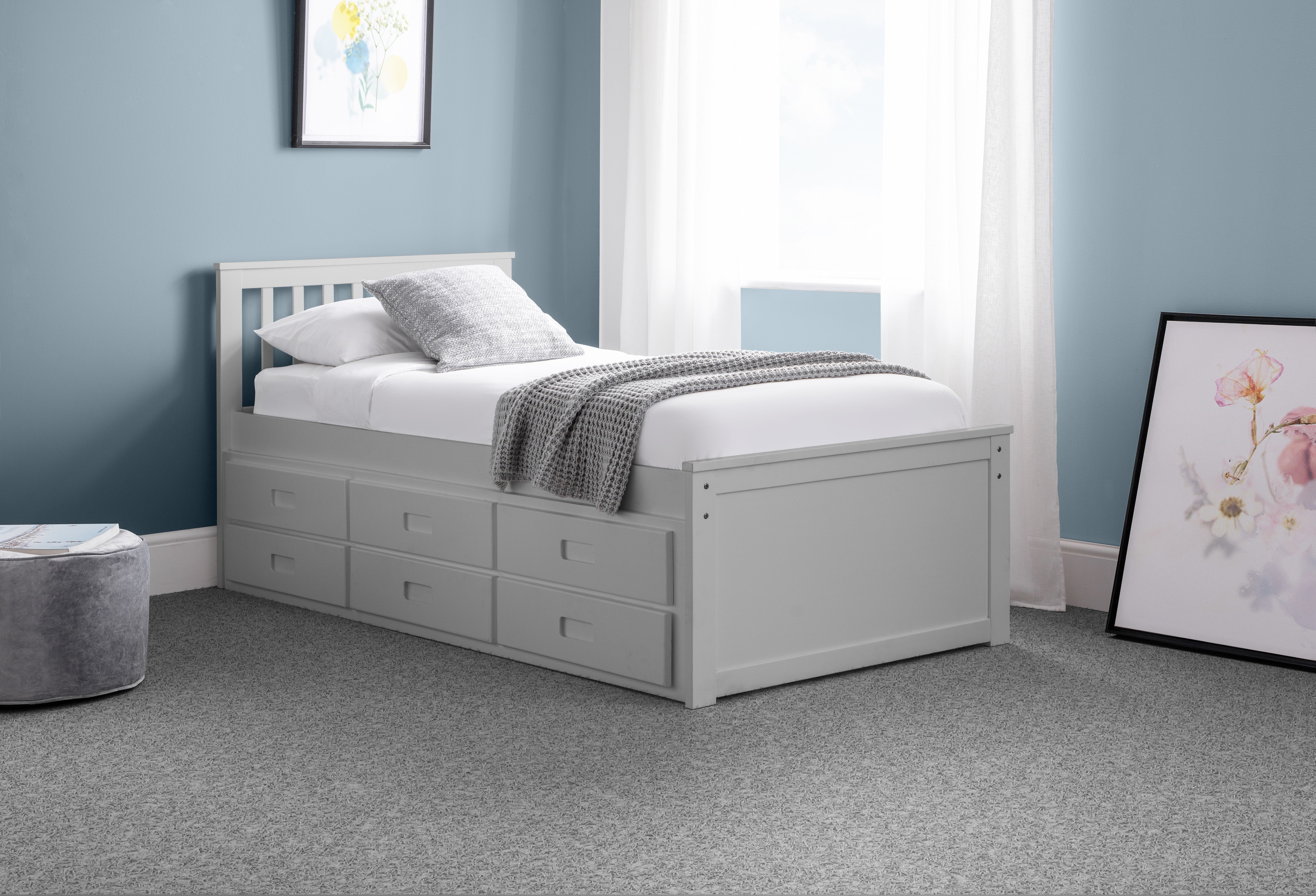 Gray bed with storage drawers in a bedroom setting