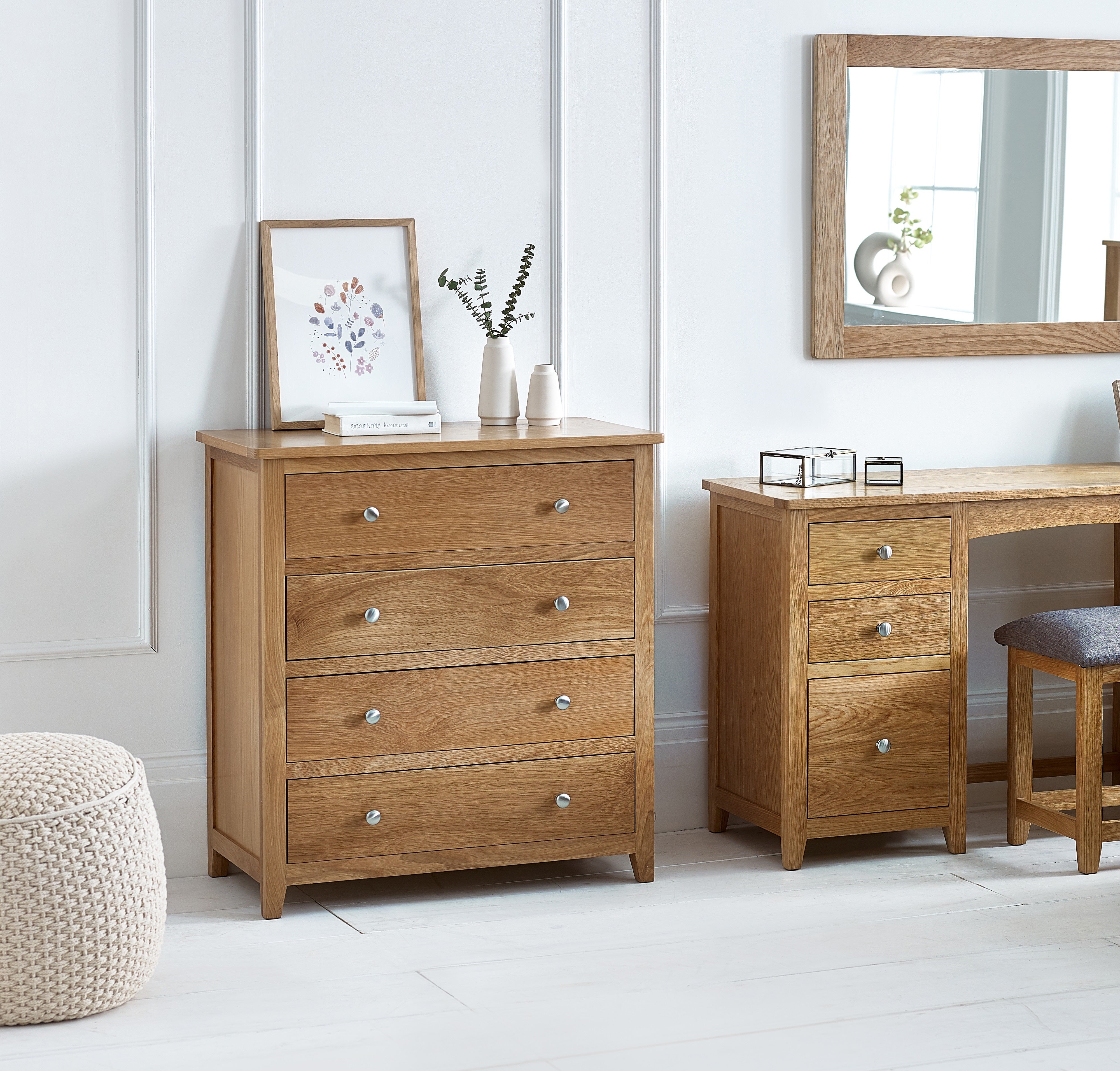 Wooden dresser and desk with decorative items in a room setting.