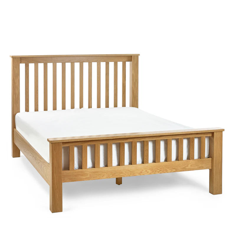 Wooden bed frame with white mattress on a white background