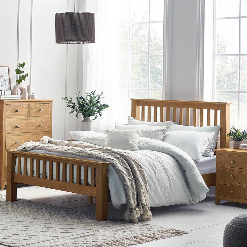 Wooden bed with white bedding in a bright bedroom