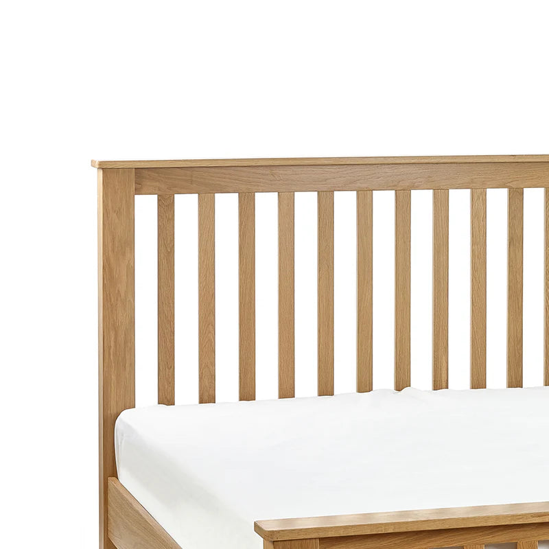 Wooden bed frame with white mattress on a white background
