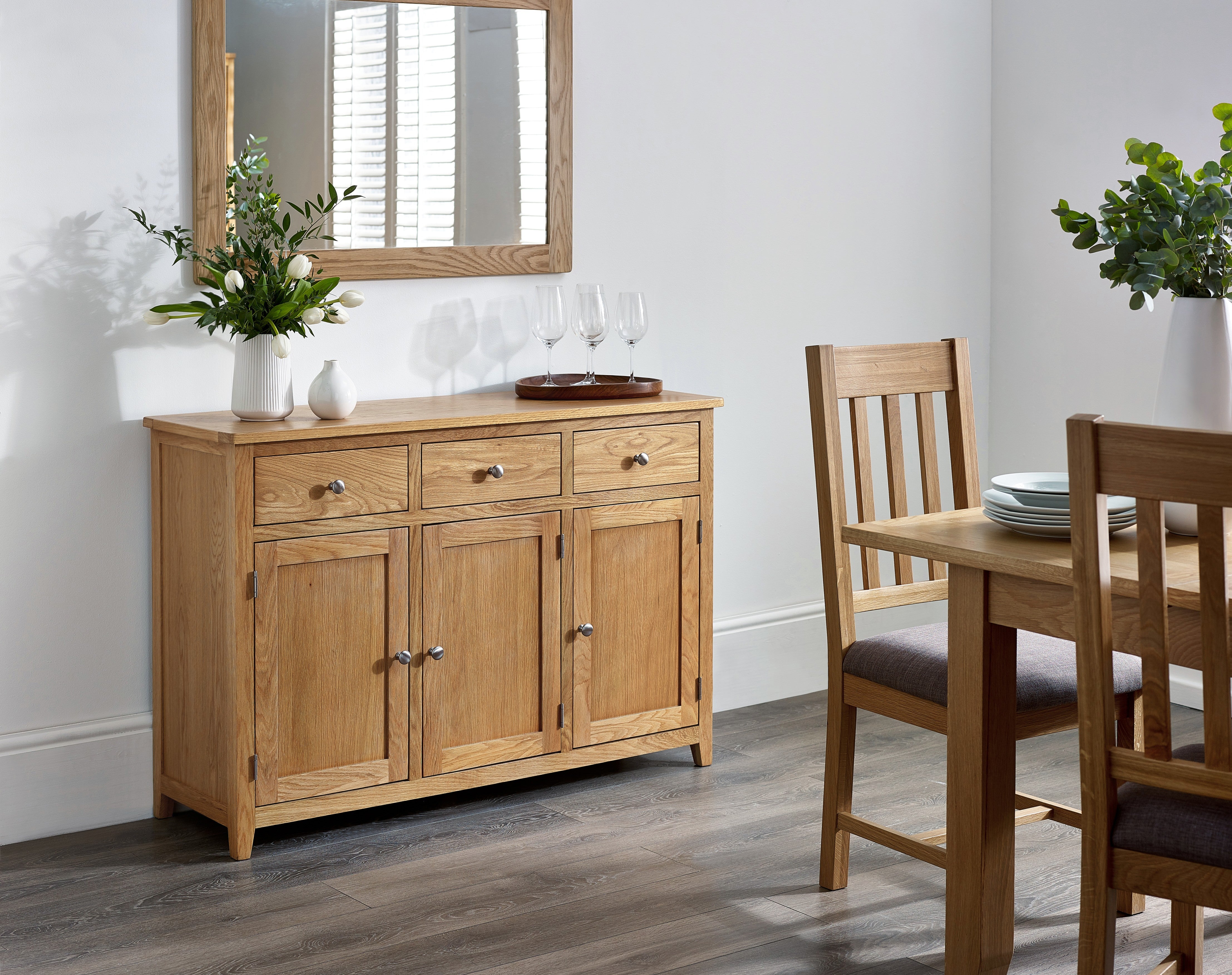 Dining room with wooden sideboard, table, and chairs.