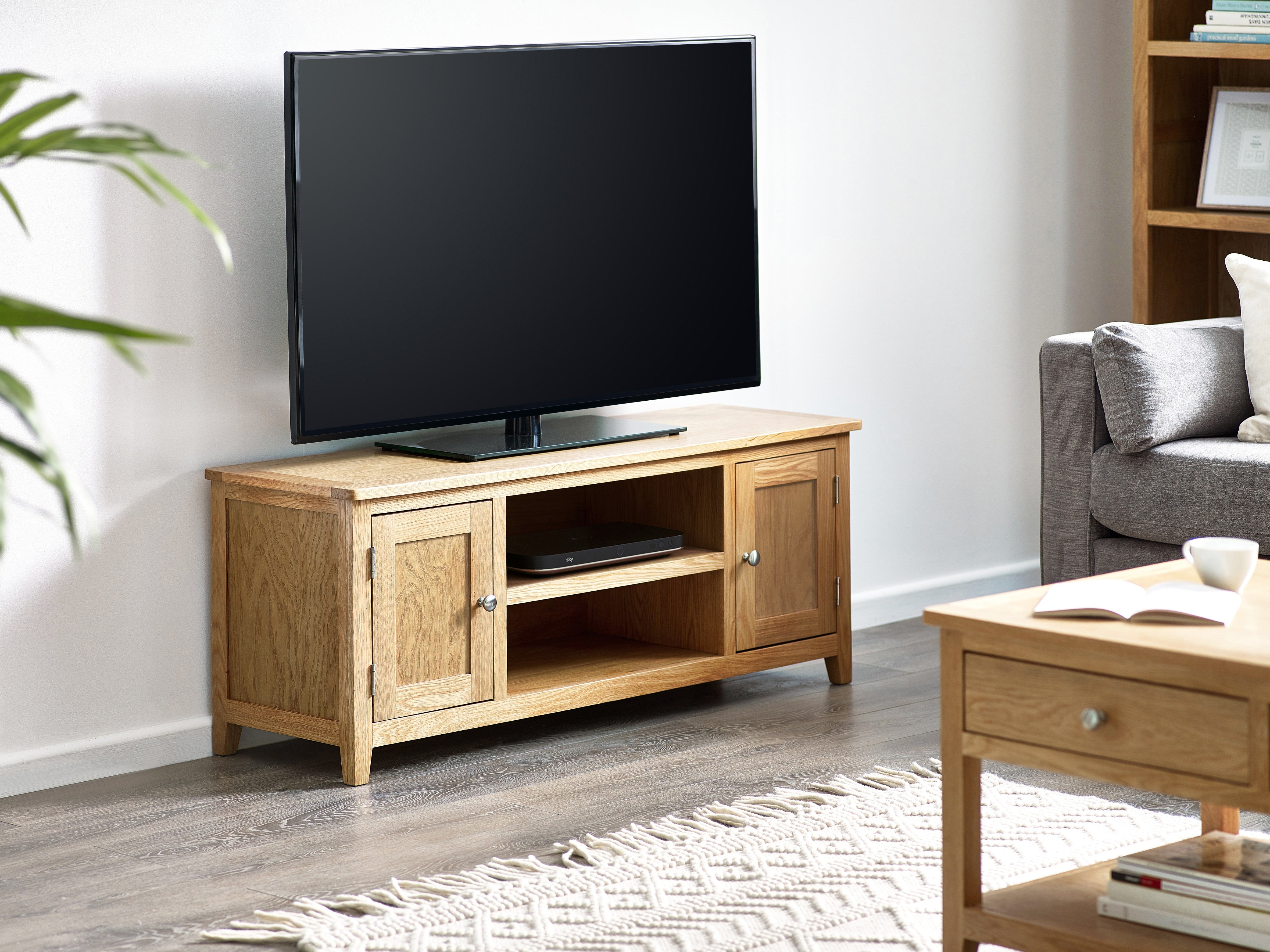 Wooden TV stand with a television in a living room setting.