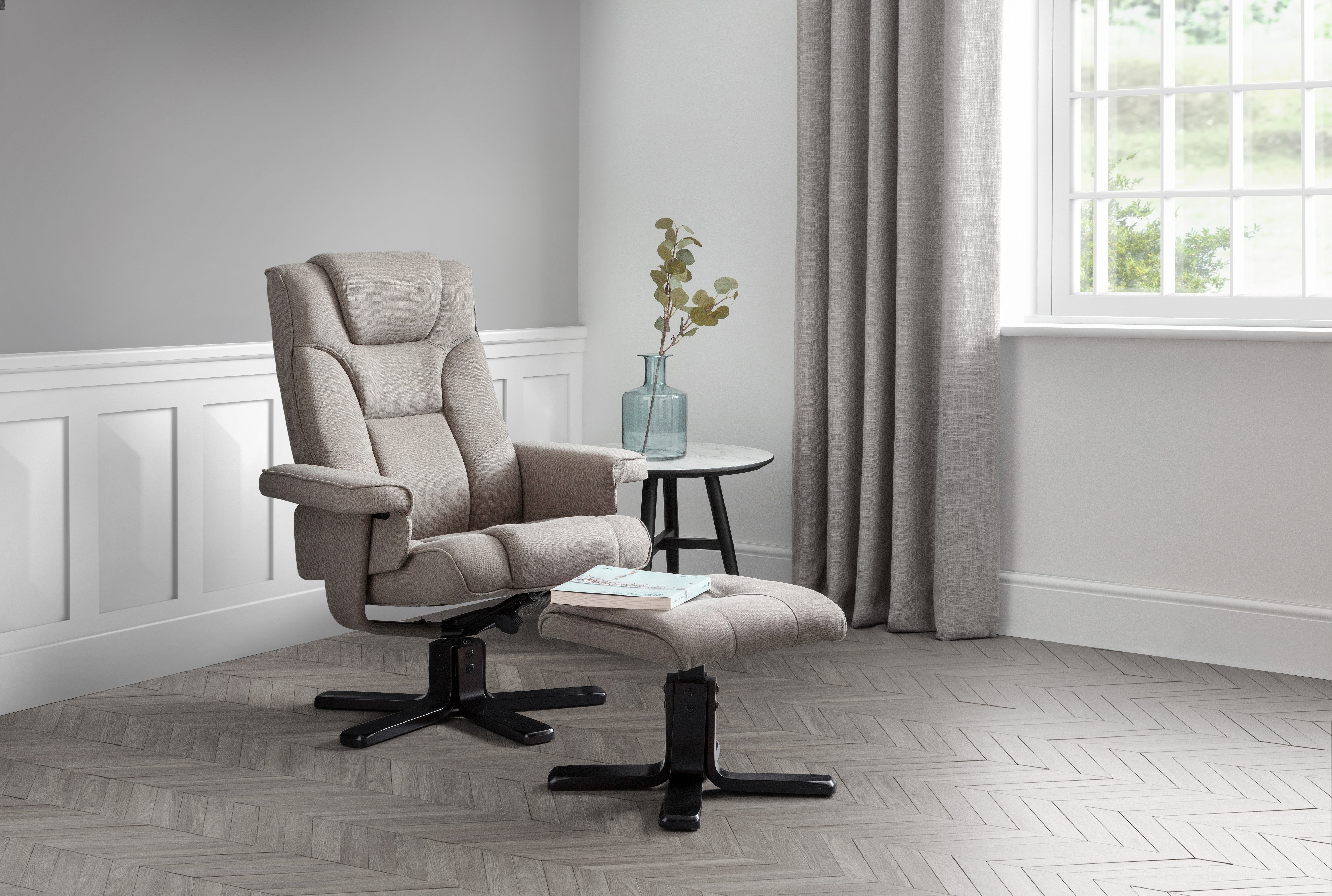 Beige recliner chair with ottoman in a room with a window and curtains.